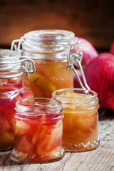 Fototapeta na wymiar Autumn apple jam ripe red apples in jars on an old wooden table,