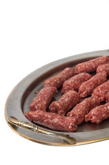 Raw kebabs aligned on the metal tray