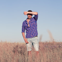Attractive young man standing in a field