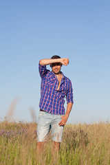 Attractive young man standing in a field