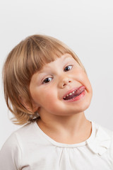 Cute Caucasian little girl shows tongue