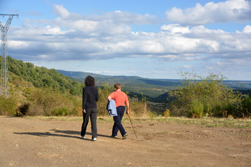 mujeres caminando por un camino de montaña