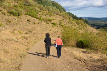 mujeres paseando por un camino de montaña
