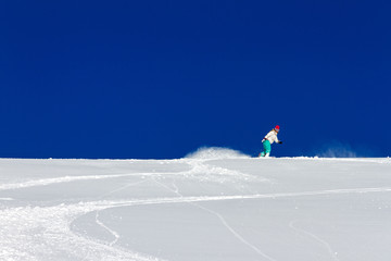 Female snowboarder rocking the slopes on a sunny morning in the Italian alps