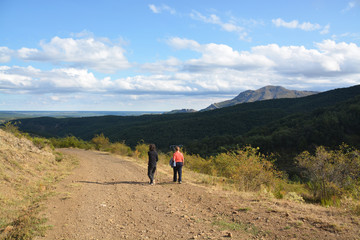 mujeres caminando por un camino de montaña