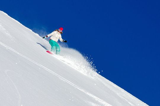 Female snowboarder rocking the slopes on a sunny morning in the Italian alps