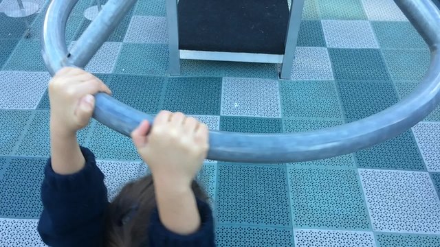 Slow motion of a child girl age 05 play on a carousel in playground