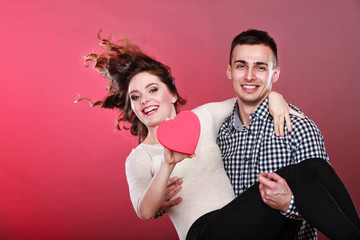 Man holds woman with paper heart