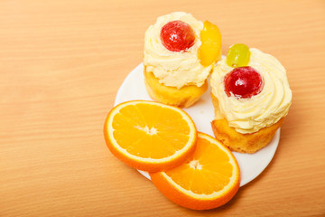 Gourmet cream cake cookie and orange on plate