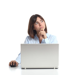 Pensive woman thinking while is using a laptop