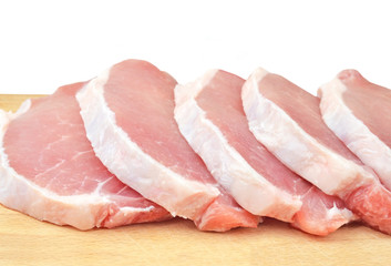 Raw meat steaks on wooden board, isolated on white background