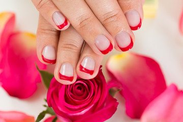 Hands With Manicured Nail Varnish Placed On Roses