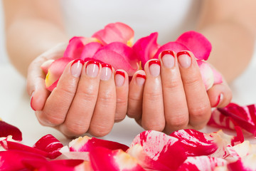 Obraz na płótnie Canvas Female Hands With Nail Varnish Holding Rose Petals