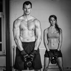 man and woman lifting kettle bell crossfit