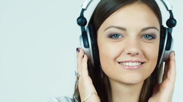 Attractive dark-haired woman listening to music on headphones