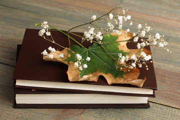 Dried flowers and books on wooden background