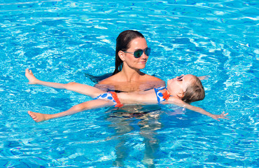 happy little girl and  mother in pool