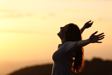 Back light of a woman breathing raising arms