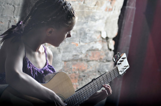  teenage girl playing guitar