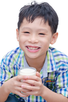 Asian boy drinking a glass of milk over white background