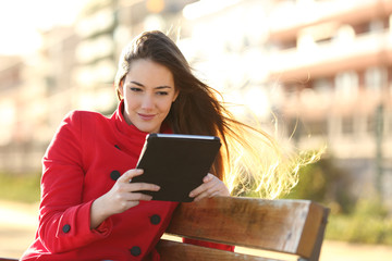 Woman reading an ebook or tablet in an urban park