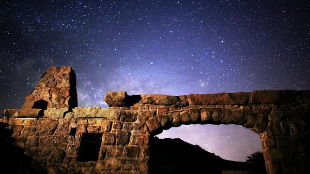  Astrophotography time lapse footage with tilt up motion of milky way galaxy rising over abandoned brick ruin structure at Knapp's Castle in Santa Barbala, California