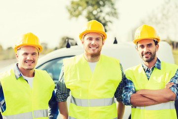 group of smiling builders in hardhats outdoors