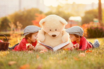 Two adorable little boys with his teddy bear friend in the park - Powered by Adobe