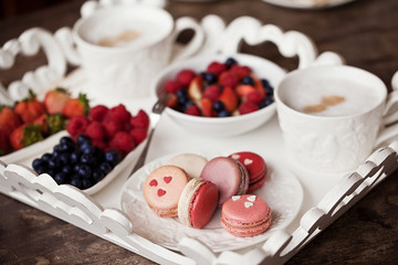 Sweet breakfast with strawberry, blueberry, raspberry, cappuccino and muesli on white vintage tray