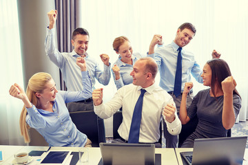 business people celebrating victory in office