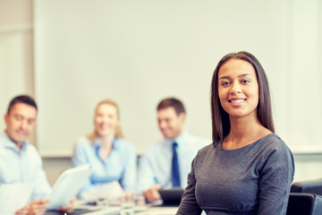 group of smiling businesspeople meeting in office