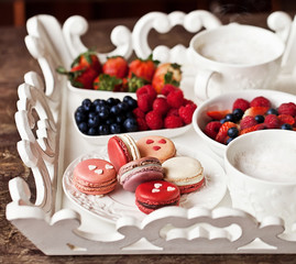 Sweet breakfast with strawberry, blueberry, raspberry, cappuccino and muesli on white vintage tray