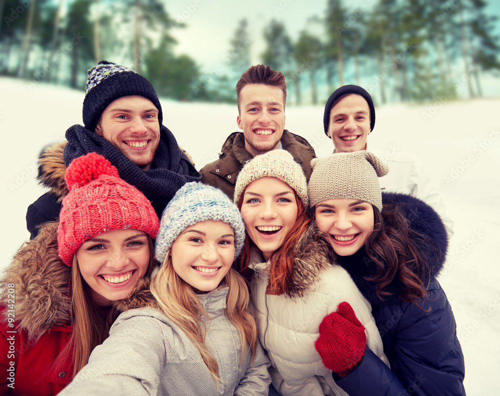 Poster group of smiling friends taking selfie outdoors