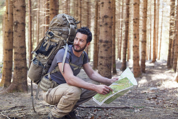 Man with Backpack and map searching directions