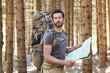 Man with Backpack and map searching directions
