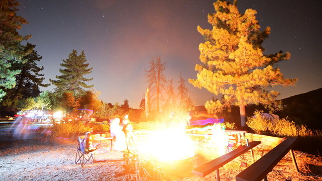 Time lapse footage with zoom in motion of a group of campers surrounding bonfire in alpine mountain in Angels National Forest, California