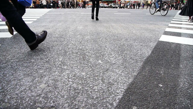 Footsteps of commuters in famous Shibuya crosswalk at rush hour in Tokyo, Japan
