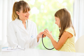 Little girl playing with her doctors stetoscope