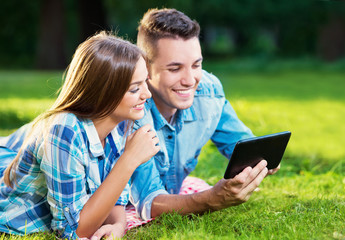 Two young people with a tablet outside 