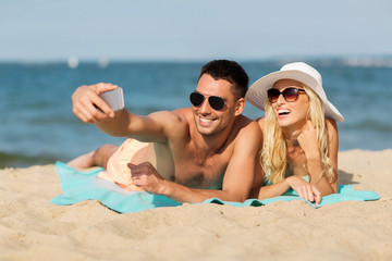 happy couple in swimwear walking on summer beach