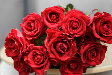 Naklejka premium bouquet of red roses lying on a plate