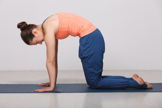 Beautiful sporty fit yogini woman practices yoga asana marjarias