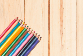 Close up stack colour pencils on wooden background