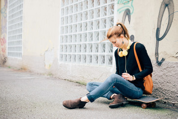 young beautiful hipster sporty blonde woman sitting on her skate