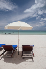 Beach on tropical island. Clear blue water, sand, clouds. 
