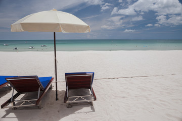 Beach on tropical island. Clear blue water, sand, clouds. 