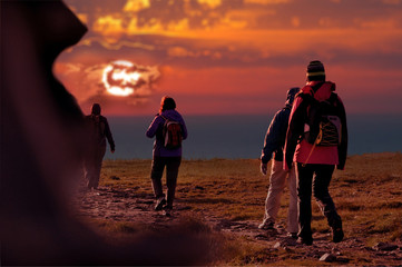 Persone in montagna camminano al tramonto