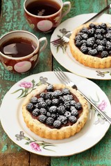 Fancy cake with blackberries and chocolate cream with icing suga