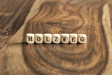 German word HOLZWEG (means wrong track) on wooden cubes