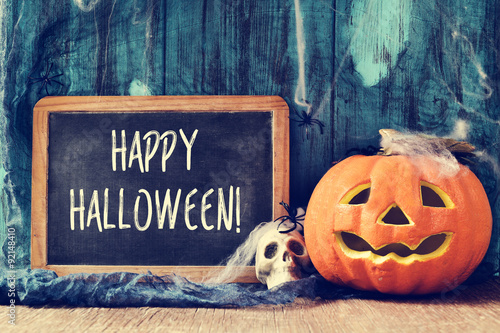 skull, jack-o-lantern and text happy halloween in a chalkboard